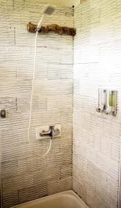 bagno con doccia e tubo a muro di Amed Cafe & Hotel Kebun Wayan ad Amed