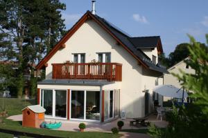 une maison avec un balcon au-dessus dans l'établissement BnB "Les Coquelicots", à Mies