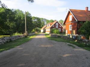 uma estrada vazia numa aldeia com casas em Länsmansgården em Färjestaden