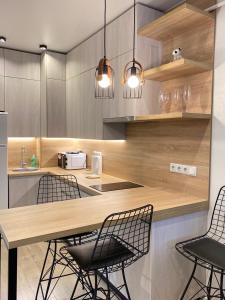 a kitchen with a counter with chairs and a table at Апартаменты SUOMI в жк Империал in Truskavets