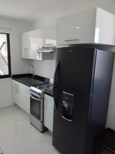 a kitchen with a black refrigerator and a stove at Venecia 262 in Puerto Vallarta