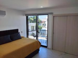 a bedroom with a bed and a sliding glass door at Venecia 262 in Puerto Vallarta