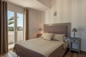 a bedroom with a bed and a large window at Daedalus Hotel in Fira