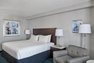 a hotel room with a bed and a chair at Chelsea Hotel Toronto in Toronto