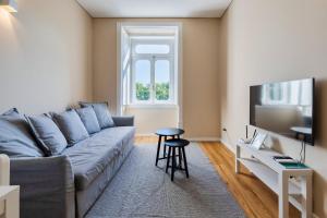 a living room with a couch and a tv at Setubal Prime in Setúbal