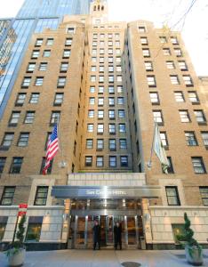 een hoog gebouw waar mensen voor staan bij San Carlos Hotel New York in New York