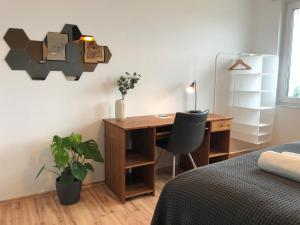 - une chambre avec un bureau, un lit, un bureau et une chaise dans l'établissement LIME HOMES: Balkon, Küche, Netflix, à Barsinghausen