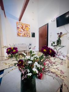 eine Vase voller Blumen auf einem Tisch in einem Zimmer in der Unterkunft West Sardinia Apartment 2 in Càbras