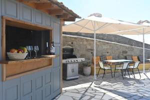 een patio met een tafel met stoelen en een parasol bij Dolce Vista - Sea View Apartments in Parikia