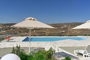 een zwembad met twee parasols en stoelen en een zwembad bij Dolce Vista - Sea View Apartments in Parikia