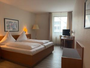 a hotel room with a bed and a desk at Hotel Aulmann in Trier