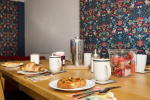 a wooden table with plates of food on it at Blue Sparrow House - parking in Portsmouth