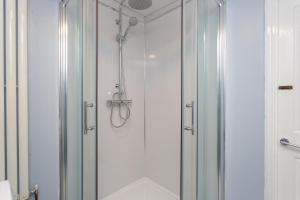 a shower with a glass door in a bathroom at Blue Sparrow House - parking in Portsmouth