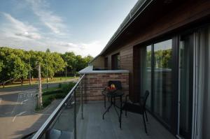 een balkon met een tafel en een stoel erop bij Almásy Apartmanház Gyula in Gyula