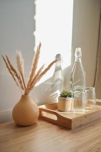 uma mesa de madeira com garrafas e uma planta em vasos em AUBERGE DU DIMANCHE - Hotel - Fjord-du-Saguenay - l'Anse-Saint-Jean - Riviere-Eternite em Riviere Eternite