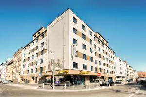 维也纳B&B Hotel Wien-Stadthalle的一条街道上白色的大建筑,有街灯