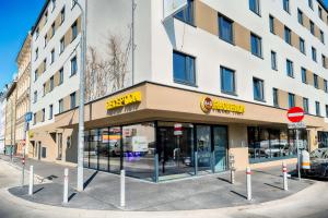 维也纳B&B Hotel Wien-Stadthalle的街道上建筑物前面的商店