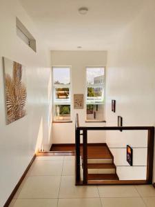 a hallway with stairs and windows in a house at Fiorella Beach House, Diani Beach in Diani Beach