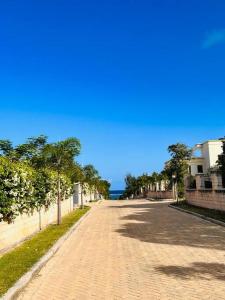 a cobblestone street with trees on the side of the road at Fiorella Beach House, Diani Beach in Diani Beach