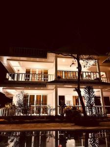 a large white building with a tree in front of it at Fiorella Beach House, Diani Beach in Diani Beach