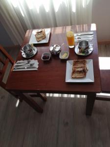 una mesa de madera con un plato de comida. en Hotel CESARE, en Uyuni