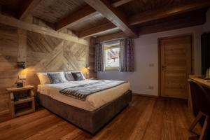 ein Schlafzimmer mit einem Bett und einer Holzwand in der Unterkunft Fleur des neiges & Spa - Adults only in Ayas