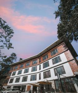 a building with a cloudy sky behind it at Tree of Life Indra Mandala Hotel, Gangtok in Gangtok