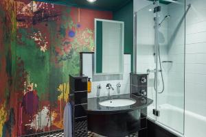 un baño con lavabo y una pintura en la pared en Malmaison Manchester, en Mánchester