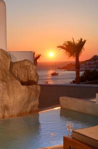 una piscina con una puesta de sol en el fondo en Anax Resort and Spa, en Agios Ioannis Mykonos