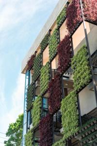 un immeuble d'appartements avec des plantes sur son côté dans l'établissement Hotel Dumaguete, à Dumaguete