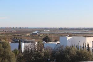 um grande edifício branco num campo com árvores em ÁTICO ATALAYA Parking privado gratis em Ayamonte