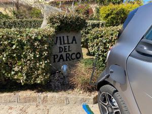 un cartello di pietra che Readsilla del Paza vicino a un'auto di Hotel Villa Del Parco a La Maddalena