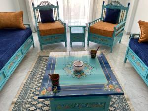 a living room with blue furniture and a table and chairs at Marsa Central Splendid Appart 2 in La Marsa