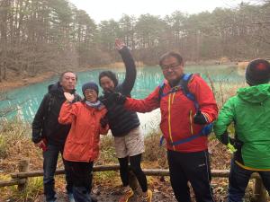 un groupe de personnes debout devant un étang dans l'établissement Lake village donaludo Pension, à Kitashiobara