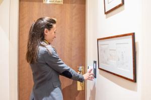 a woman opening the door to a room at Queens Boutique Hotel in Paris