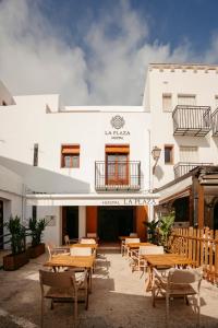 un restaurant avec des tables et des chaises en face d'un bâtiment dans l'établissement La Plaza Hostal, à Peñíscola