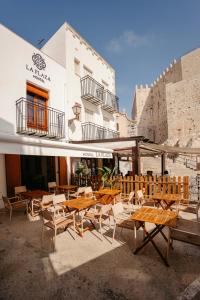 un groupe de tables et de chaises devant un bâtiment dans l'établissement La Plaza Hostal, à Peñíscola