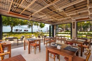 um restaurante com mesas e cadeiras e vista para o oceano em The Culture Samui em Bangrak Beach