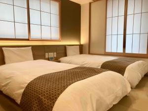 A bed or beds in a room at Dormy Inn Premium Ginza