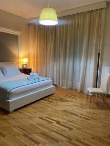 - une chambre avec un lit, une chaise et une lampe dans l'établissement Elegante apartamento centrale, à Tríkala