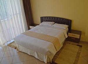 duże łóżko w sypialni z dużym oknem w obiekcie Norfolk Towers Serviced Apartment -Nairobi, City Centre CBD w mieście Nairobi