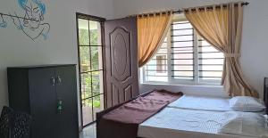 PRAKRITI HOMESTAY Fortkochi Air Conditioned Rooms tesisinde bir odada yatak veya yataklar