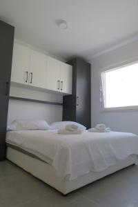 - une chambre avec un grand lit blanc et une fenêtre dans l'établissement Villa Omazic, à Trogir