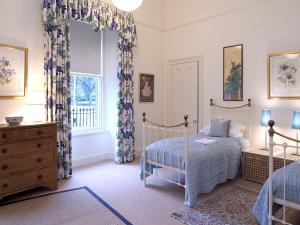 um quarto com uma cama, uma cómoda e uma janela em 1 Bellevue Terrace em Edinburgo