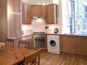 uma cozinha com uma máquina de lavar roupa e uma mesa em 1 Bellevue Terrace em Edinburgo