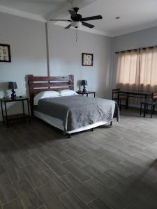 - une chambre avec un lit et un ventilateur de plafond dans l'établissement Wally’s Place, à Estelí