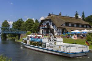 łódź na rzece przed budynkiem w obiekcie Hotel & Restaurant Lenzer Krug w mieście Lenz