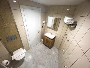 a bathroom with a toilet and a sink and a shower at Helen Inn in Izmir