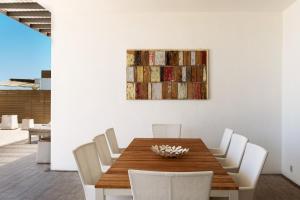 a dining room with a wooden table and white chairs at Cap Ouest by Horizon Holidays in Flic-en-Flac