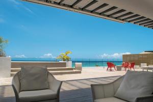 a patio with chairs and a view of the ocean at Cap Ouest by Horizon Holidays in Flic-en-Flac